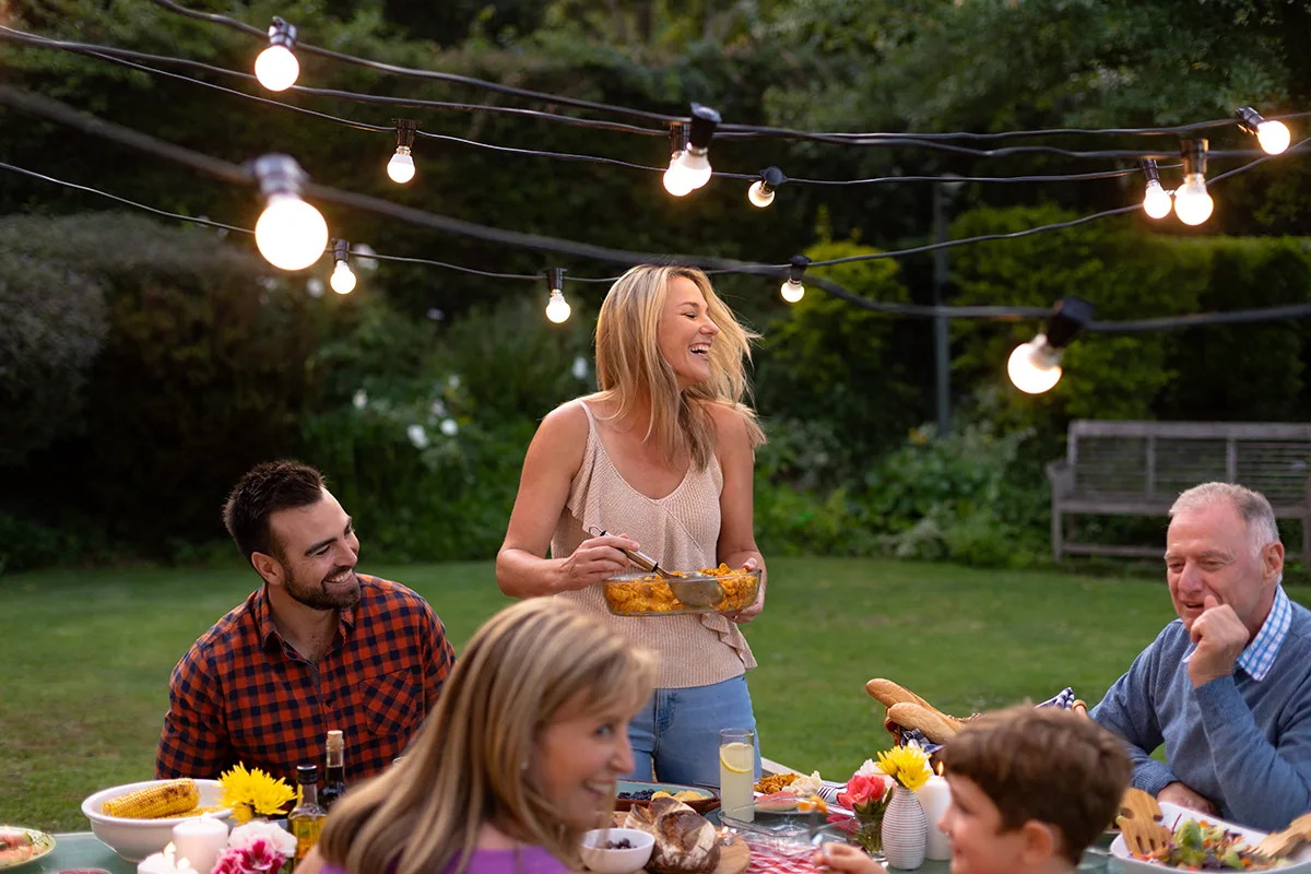 Family enjoying a bbq in the garden with fairy lights